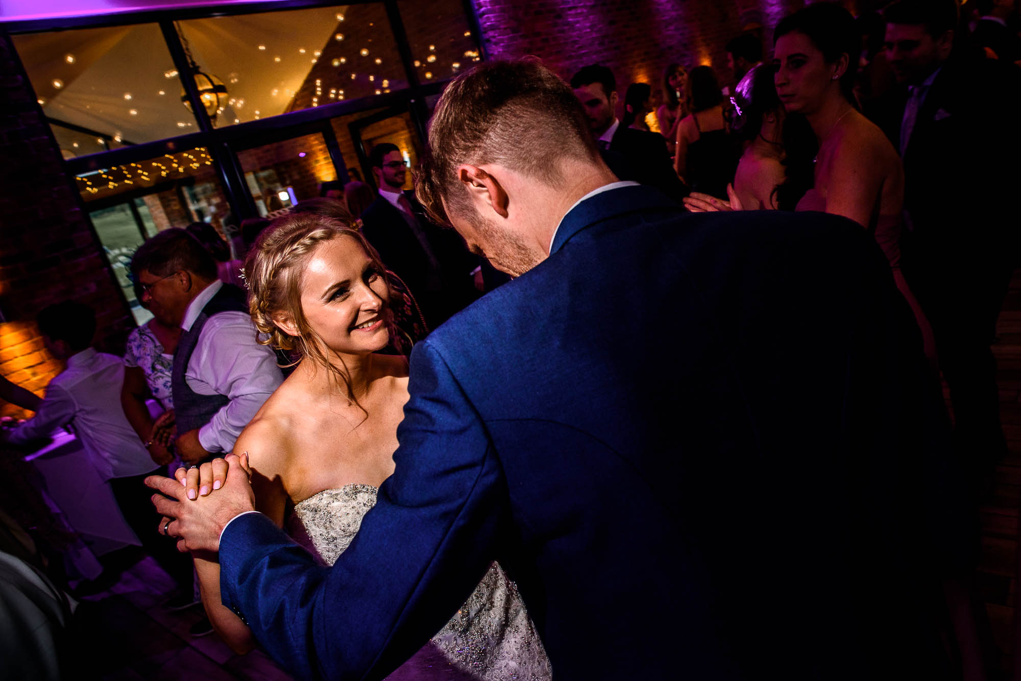 Bride and Groom dance together on a full dancefloor