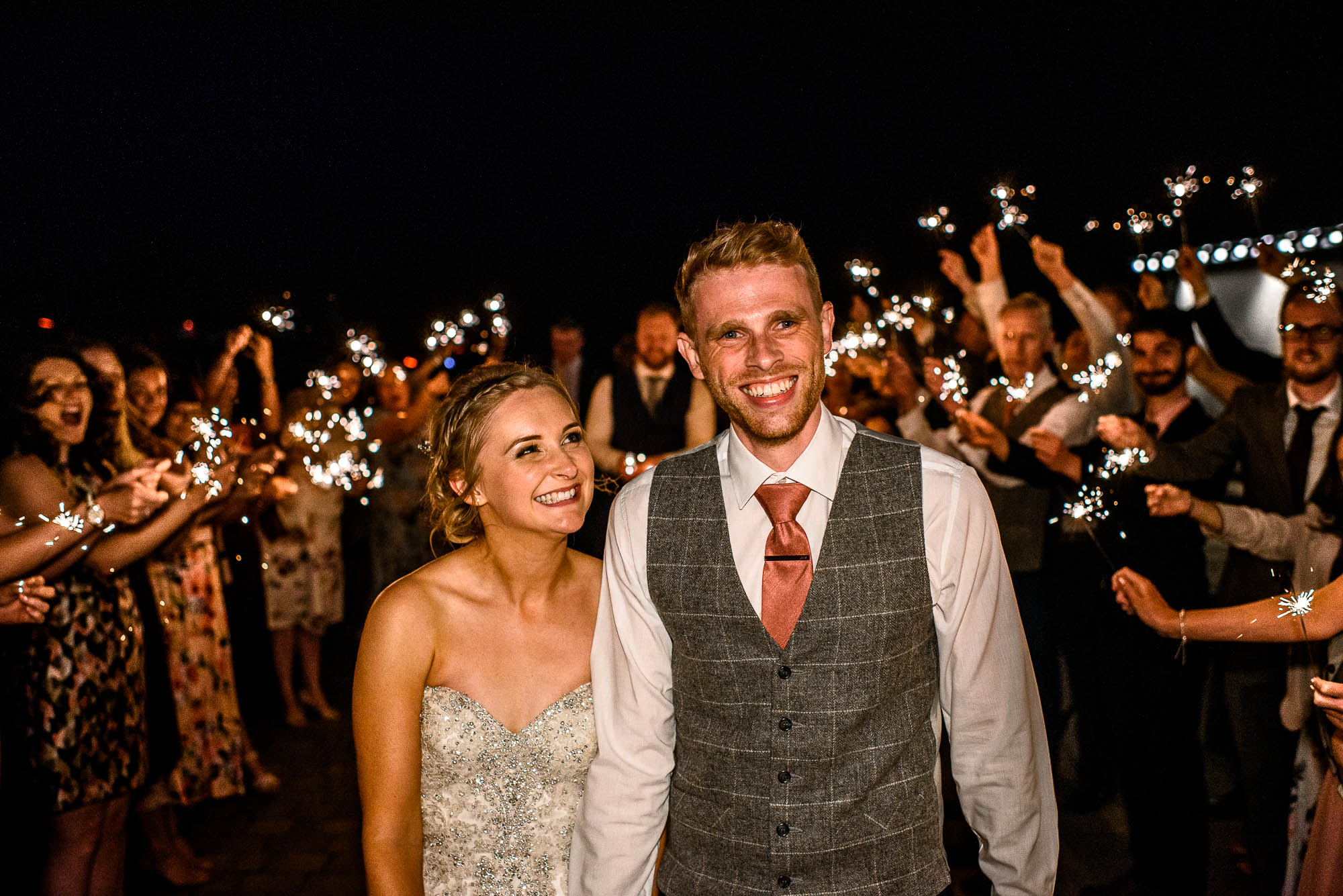 Bride and Groom walk through sparkler archway