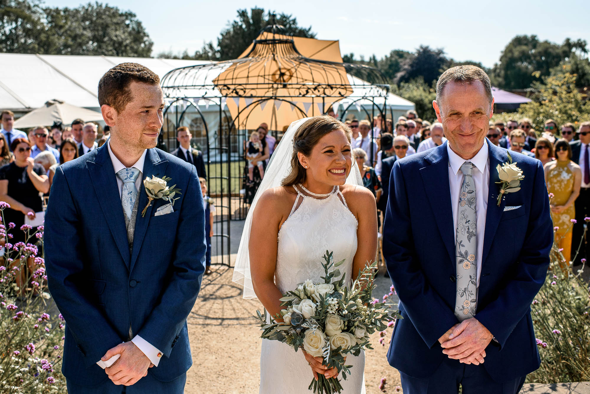 Groom looks at Bride during outside wedding service