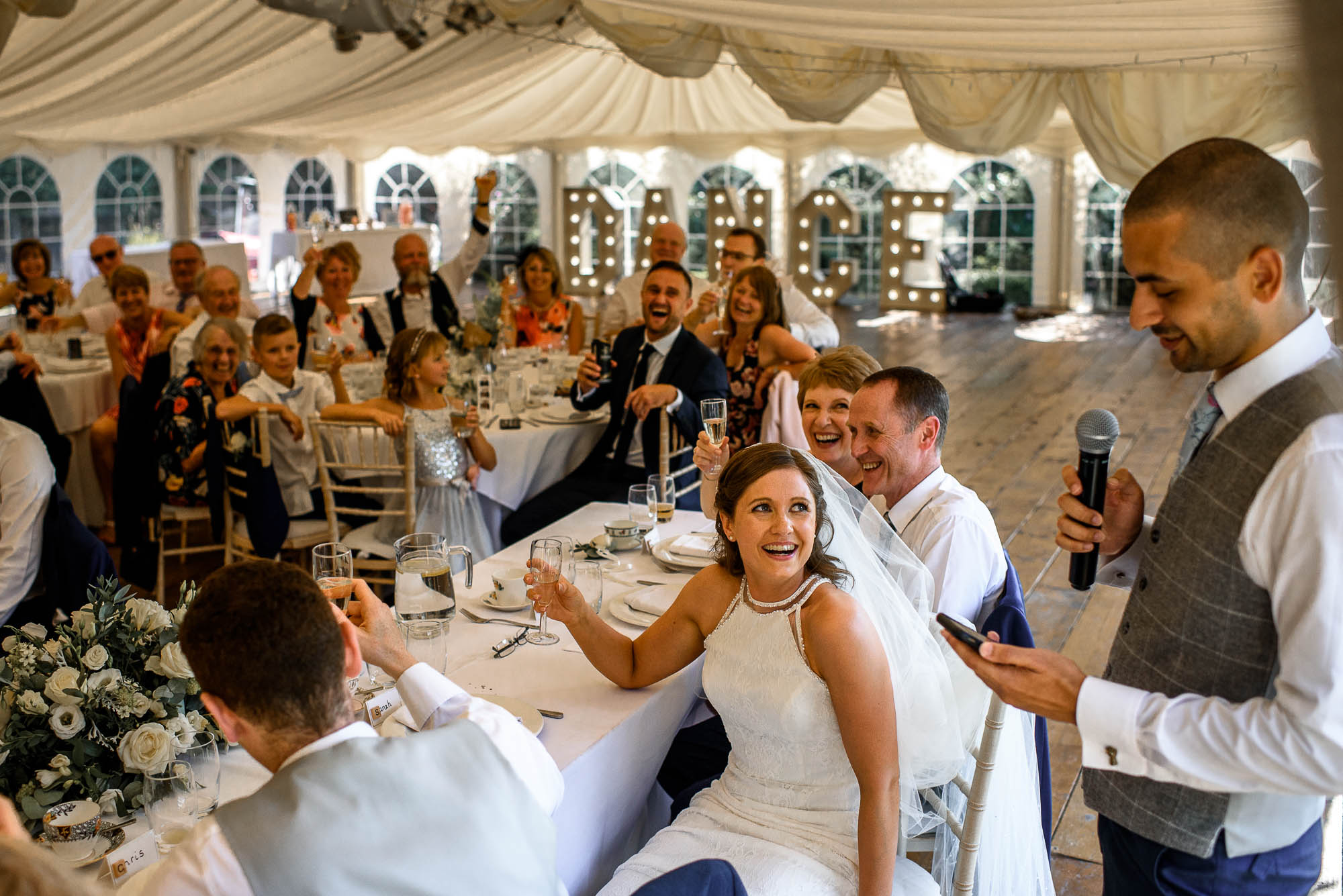 Bride looks at bestman during wedding speeches